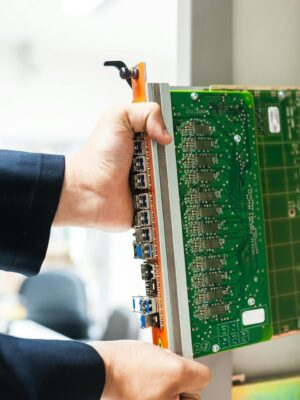 A technician inserts a circuit board into a server rack, illustrating technology and connectivity.